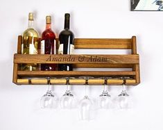 wine glasses and bottles are sitting on a wooden rack with the names amanda and adam