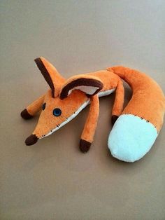 an orange stuffed animal laying on top of a table