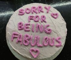 a white cake with pink frosting saying sorry for being fabulous