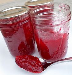 two jars filled with jam and a spoon