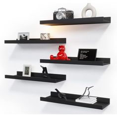 three black floating shelves on the wall with pictures and other items sitting on top of them