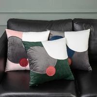 a black leather couch with four different colored pillows sitting on it's back end