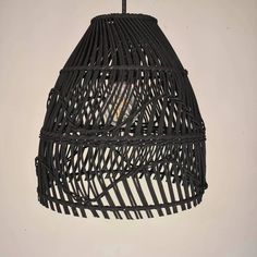 a light that is hanging from the ceiling with wicker material on it's side