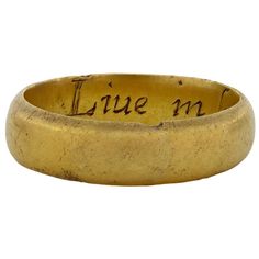 an old gold ring with writing on it