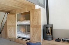 bunk beds are built into the side of a wall in a room that has stairs leading up to them