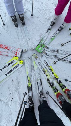 several people standing in the middle of a circle with their skis on top of them