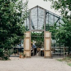 an outdoor greenhouse with people working in it