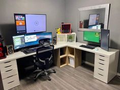 a computer desk with two monitors and a laptop on it in an office space that is painted gray