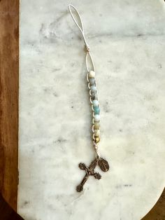 a cross on a marble table with beads