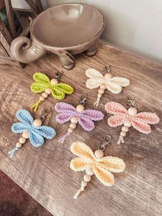 small crocheted dragonflys are sitting on a table next to a teapot