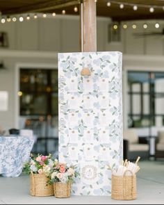 an outdoor area with flowers and baskets on the ground next to a tall paper bag