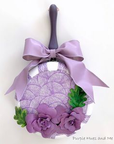 purple flowers are tied to the handle of a wine bottle with a ribbon around it