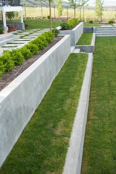 an outdoor garden area with grass and stone edgings on the side of it