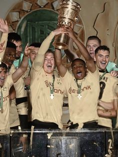 a group of men holding up a trophy