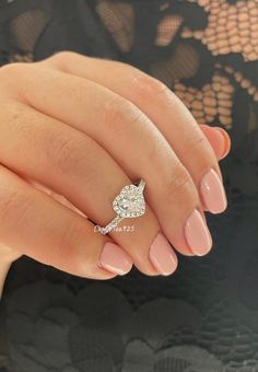 a woman's hand with a ring on her finger and an oval shaped diamond in the middle