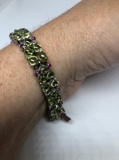 This Peridot and Ruby bracelet is very lively and bright. The stones are deep colors and well matched. The sterling silver is plated with rhodium to protect the bracelet from tarnish and give the appearance of white gold. My jeweler can shorten this for a $20 fee 7.5 inches All jewelry is shipped in a nice gift box. Check out our over a THOUSAND great reviews Engraving is $4 per letter and is not always perfect depending on the piece. It can take a few days if the jeweler is busy. This is payabl Green Multi-stone Round Bracelets, Green Peridot Multi-stone Jewelry, Green Bangle Tennis Bracelet For Anniversary, Green Multi-stone Bracelets For Gifts, Anniversary Green Sterling Silver Bracelets, Green Jubilee Bracelet For Anniversary, Green Sterling Silver Bangle Bracelet, Silver Bracelets With Peridot Gemstone, Silver Peridot Gemstone Bracelets