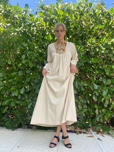 "Cream natural cotton maxi dress with pleated bodice, barkcloth neckline, belled sleeves, and back zipper. Bust: 40\" Waist: 44\" Hips: 60\" Total length: 55\" Circa: late 1960's, early 1970's Condition: Good vintage condition. Normal wear. For fun stuff, follow us on IG---closetcasevintage instagram.com/closetcasevintage Please read our store policies." Beige Cotton Smock Dress, Smock Maxi Dress For Daywear, Cream Long Maxi Dress For Daywear, Long Cream Cotton Dress, Beige Cotton Maxi Dress For Daywear, Peasant Style Maxi Length Prairie Dress, Beige Cotton Peasant Dress, Neutral Maxi Length Dress For Daywear, Beige Maxi Dress For Daywear