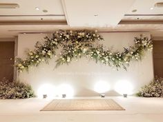 an indoor wedding setup with white flowers and greenery