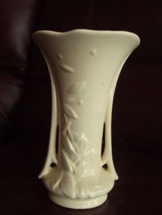 a white vase sitting on top of a table