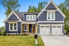 a blue house with white trim and two car garages