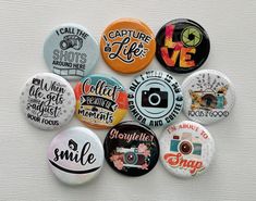 a bunch of buttons that are on a white surface with the words capture life printed on them