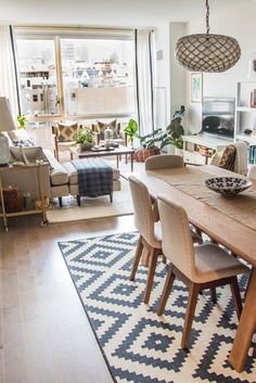 a dining room table with chairs and a rug on the floor in front of it