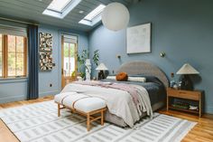 a bedroom with blue walls and wooden floors