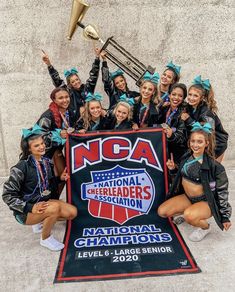 cheerleaders pose with their trophy and banner for the national cheerleader's association