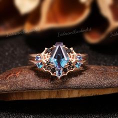 a ring with blue stones on top of a piece of wood