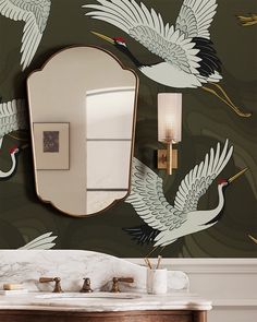 a bathroom with a mirror, sink and two birds on the wall