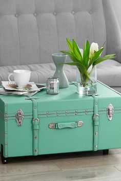 a teal suitcase sitting on top of a coffee table