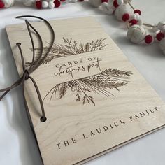 a wooden notebook with the words, cards of christmas past and pine branches on it