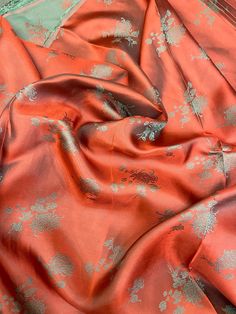 an orange cloth with silver flowers on it