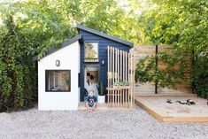 a small blue and white shed with a child in it