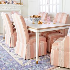 a dining room with pink chairs and a white table