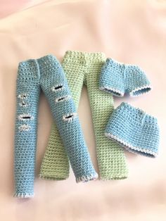 crocheted baby leg warmers and mittens laid out on a bed