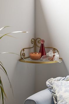 a candle is sitting on a shelf in the corner of a room next to a chair