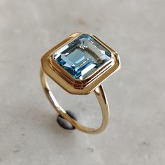 This stunning ring is set in 14k Solid Yellow Gold with Natural Sky Blue Topaz with utmost precision. It is an unique statement gemstone ring for nearly every occasion and is completely hassle-free jewelry. ITEM DETAILS * GEM: Frosted Sky Blue topaz * GEM SIZE: 8X10mm * GEM SHAPE: Octagon * Total Gem weight: 3.80 carats * Gold Purity: 14KT * Gold Weight: 2.54 gram * Total Weight of the Ring: 3.30 gram The Gold purity is guaranteed and it comes with authentic 14KT gold hallmark. Since my items are handmade, they are absolutely nickel and lead free. CUSTOMIZATION: * Size Customization is available for this ring and it is available in all ring sizes. Kindly choose your ideal ring size from the drop-down. * Gemstone customization is available and the it can be substituted with a gem of your ch Blue Topaz Ring Stamped 14k Gold, Octagon Ring, Art Deco Blue Topaz Ring As A Gift, Blue Topaz Ring With Emerald Cut And Bezel Setting, Blue Emerald Ring In 14k Gold, Modern Blue Topaz Ring In 14k Gold, Blue Emerald Cut Topaz Ring In 14k Gold, Blue Topaz Ring Art Deco Gift, Art Deco Blue Topaz Ring For Gift