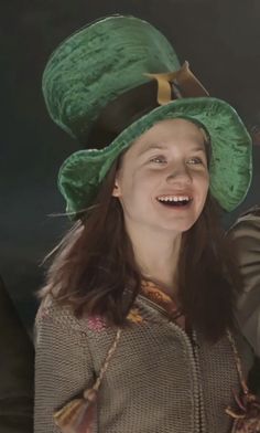 a woman wearing a green hat and smiling