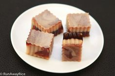 four pieces of food sitting on top of a white plate next to a black table