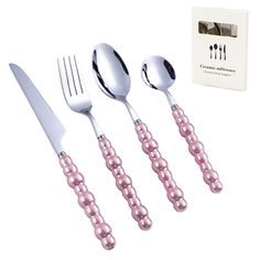 three forks, two spoons and one knife with pink pearls on the handles next to a box