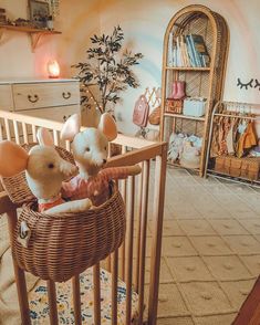 two stuffed mice sitting in a basket on top of a crib