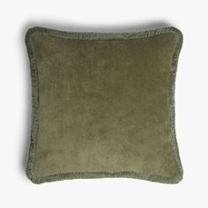 a green pillow with fringe trims on the front and back of it, against a white background