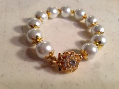 This pearl bracelet created by Jewelry By Luet and Co is made of white glass pearls, gold plated and clear crystal box clasp and gold plated beads and bead caps.  This bracelet measures 7 1/2 inches in length.All of our jewelry is unique and custom designed. We would love to assist you with any custom orders or needs for special occasions!We appreciate you shopping with Jewelry By and Luet and Co and hope you will do so often! See more items from my shop: http://www.etsy.com/shop/cdjaliFACEBOOK: White Pearl Beaded Bracelet For Wedding, White Pearl Wedding Gift Jewelry, Formal White Pearl Beaded Bracelets, Formal White Adjustable Beaded Bracelets, White Adjustable Beaded Bracelets For Formal Occasions, Elegant White Bracelets For Celebrations, White Round Pearl Bracelet For Wedding, White Beaded Bracelets With Round Beads For Wedding, Elegant Round Beads Bracelets For Celebrations