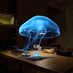 a large blue jellyfish floating in the air over a wooden table next to a laptop