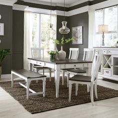 a dining room table with chairs and a bench in front of the window is shown