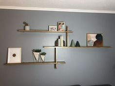 three wooden shelves on the wall with pictures and other items in them, along with bookshelves