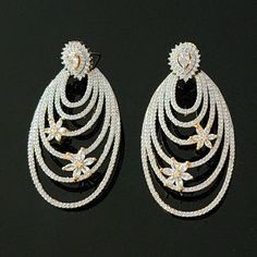 "Indulge in the exquisite radiance of these gorgeous swirl design earrings, adorned with delicate blooming flower details, and elevate your style to new heights. Expertly crafted with perfectly sized paved CZs (cubic zirconia), these earrings offer just the right amount of sparkle to enhance your look. Lightweight and comfortable, they are perfect for any occasion, whether it's a wedding, formal outing, or a night out on the town. You can even add a touch of glamour to your everyday casual outfits with these versatile earrings. Don't miss out on the opportunity to add these stunning earrings to your jewelry collection today. Measurements 2.5\" L" Everyday Casual Outfits, Wedding Formal, Design Earrings, Earrings Wedding, Swirl Design, Stunning Earrings, Blooming Flowers, Gold Plated Earrings, Earrings Dangle