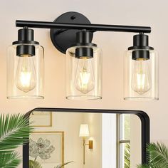 three light bathroom fixture with clear glass jars on the wall and mirror in front of it