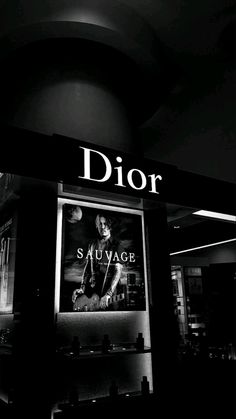 a black and white photo of a dior store front with the words sau vage on it